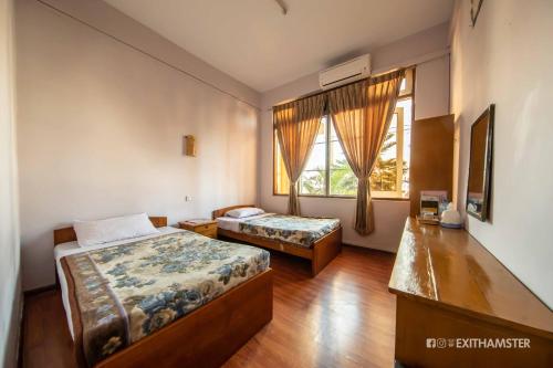 a hotel room with two beds and a window at Gypsy Inn in Nyaungshwe Township