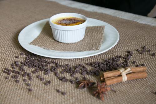 a cup of coffee sitting on a plate with coffee beans at Hotel Terme Abano Verdi in Abano Terme