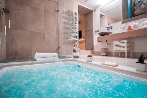 a bathroom with a large tub with blue water at Antica Dimora Magi in Sorrento