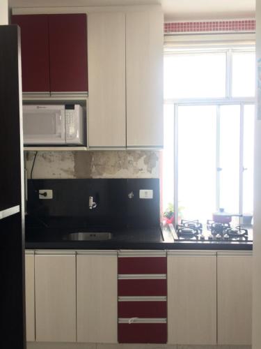 a kitchen with white cabinets and a microwave at Sweet Home Home Office - Centro de São Paulo, ao lado do metrô Anhangabaú in Sao Paulo