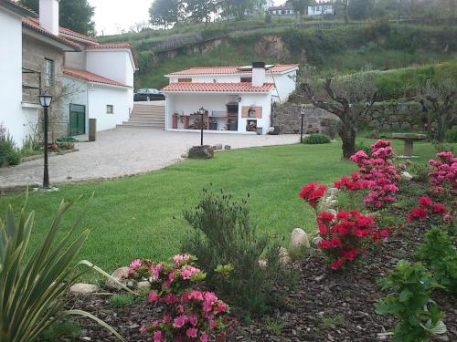 ein Haus mit rosa Blumen im Hof in der Unterkunft Quinta Vale do Nox in Serrazes