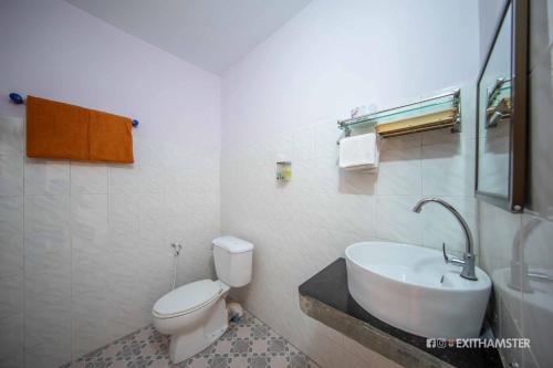 a bathroom with a white toilet and a sink at Gypsy Inn in Nyaung Shwe