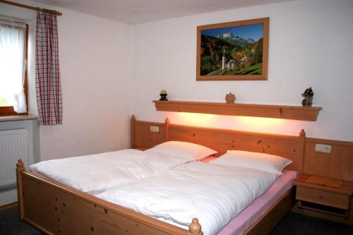 a bedroom with a large bed with white sheets at Haus Wiesenrand in Berchtesgaden