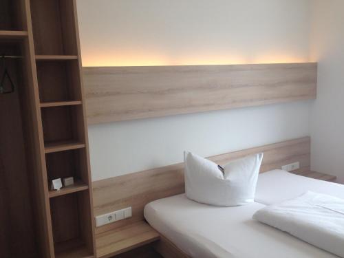 a bedroom with a white bed and a book shelf at Autohof Bitterfeld in Bitterfeld