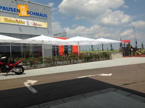 a motorcycle parked in front of a building with white umbrellas at Autohof Bitterfeld in Bitterfeld