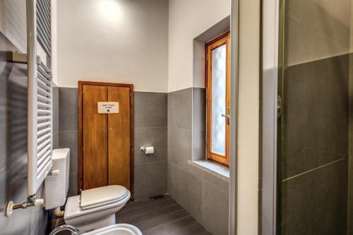 a bathroom with a toilet and a window at Guest House o Affittacamere Magenta Fico 2 in Rome