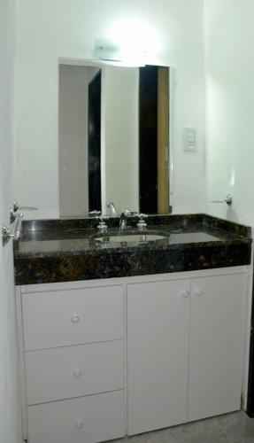 a bathroom with a sink and a large mirror at Departamentos Victorino in Ramallo