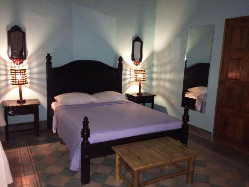 a bedroom with a bed and two lamps on two tables at Hotel La Polvora in Granada