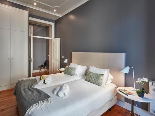 - une chambre avec un grand lit blanc dans l'établissement Lisbon Canaan Boutique Apartments Fanqueiros 114 by Get Your Stay, à Lisbonne