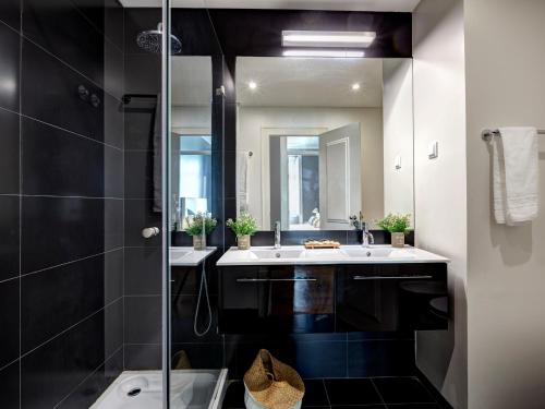 a bathroom with two sinks and a mirror at Lisbon Canaan Boutique Apartments Fanqueiros 114 by Get Your Stay in Lisbon
