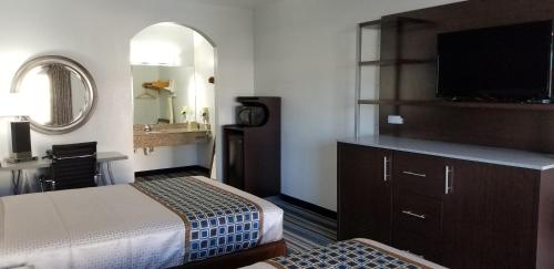 a hotel room with two beds and a flat screen tv at HomeBridge Inn and Suites in Beaumont