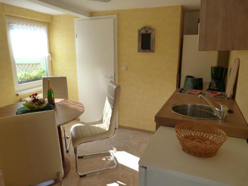 a small kitchen with a table and a sink at Ferienhaus Scheper in Bad Frankenhausen