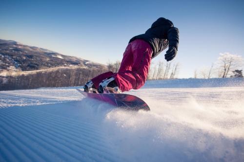 a person riding a snowboard in the snow at Mont Blanc Hôtel & Condos in Mont-Blanc