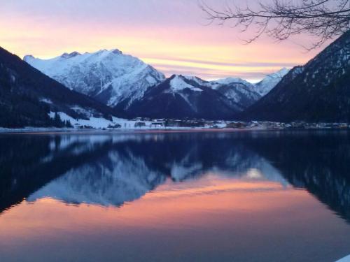 a view of a lake with snow covered mountains at Landhaus Rofan in Maurach