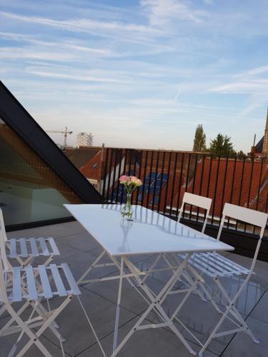 a white table and chairs on a balcony at Homey - Kortrijk in Kortrijk