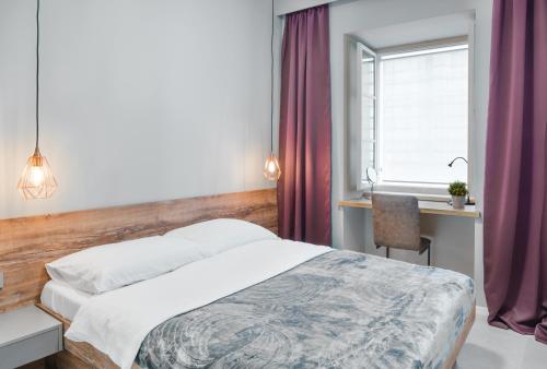 1 dormitorio con cama, escritorio y ventana en St. Mark's Boutique Apartment Zagreb, en Zagreb