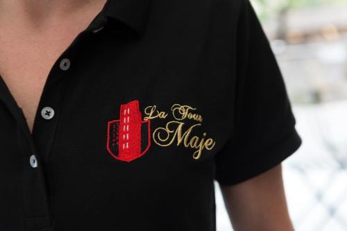 a person wearing a black shirt with a logo at Hôtel Tour Maje in Rodez