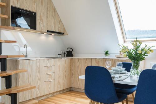 a kitchen with a dining table and blue chairs at Rezydencja Zakopiańska in Zakopane
