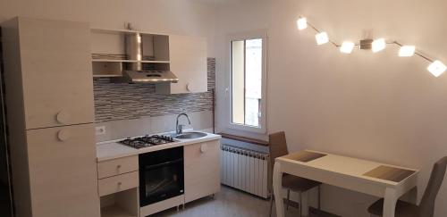 a kitchen with a stove and a sink and a table at House 149 in Ferrara