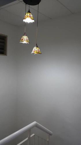 three lights hanging from a ceiling in a room at Permata Impian in Bangi
