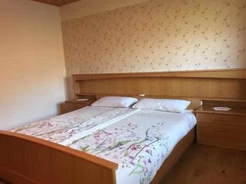 um quarto com uma cama grande e uma colcha floral em Ferienwohnung Bechter em Hittisau