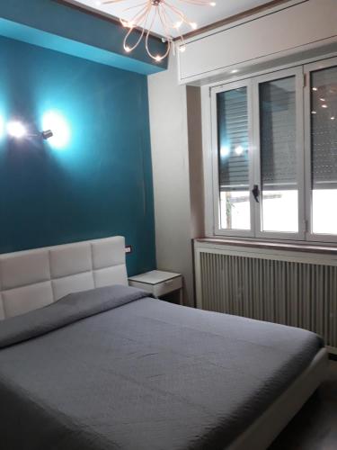 a bedroom with a bed and a blue wall at Sira House Milano in Milan