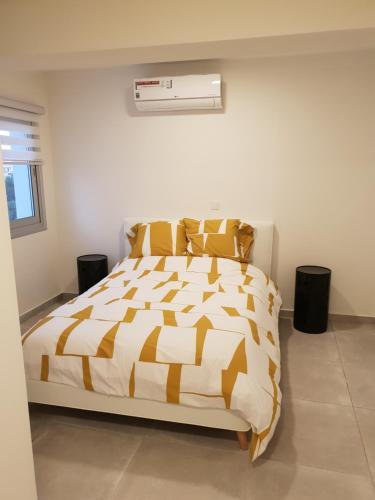 a bedroom with a bed with a yellow and white comforter at Egkomi Luxury Suites in Nicosia