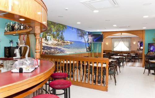 
a kitchen filled with tables, chairs, and a television at Hotel Playa Sol in El Arenal
