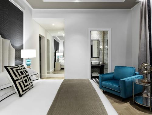 a hotel room with a bed and a blue chair at Albergo Gelsomino in Kos Town