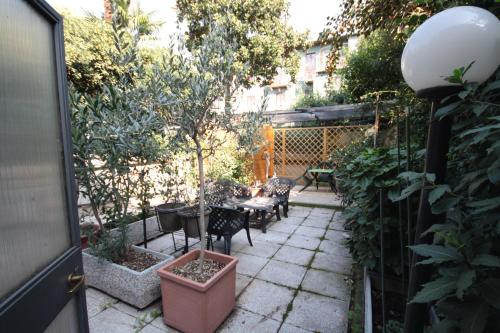 a patio with chairs and a table in a garden at Hotel Astrid in Milan