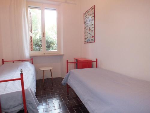 a bedroom with two beds and a window at Appartamento Montecristo 1 in Marina di Campo
