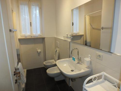a bathroom with a sink and a toilet and a mirror at Appartamento Montecristo 1 in Marina di Campo