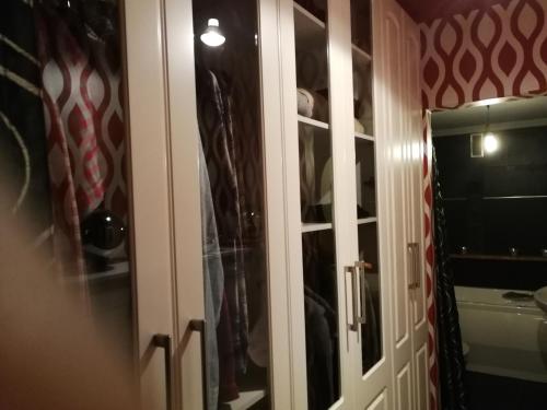 a closet with a glass door with clothes at Habitación con garage in Bilbao
