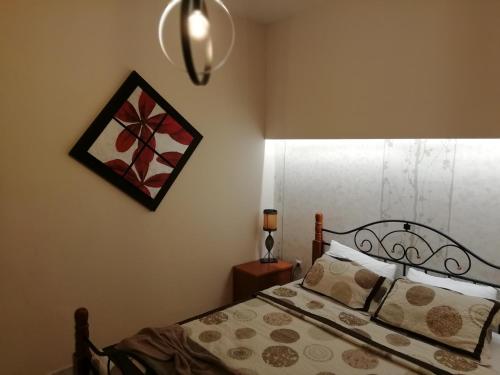 a bedroom with a bed and a picture on the wall at Vai Guesthouse Neraida in Neráïdha