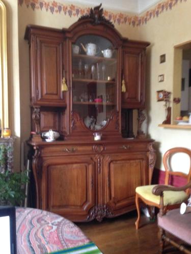 - un grand meuble en bois dans le salon dans l'établissement Chambre chez l'habitant sur petite place, à Reims