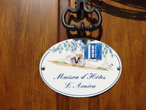 a sign on a door with a bike on it at Maison d'hôtes l'Arnica in La Bréole