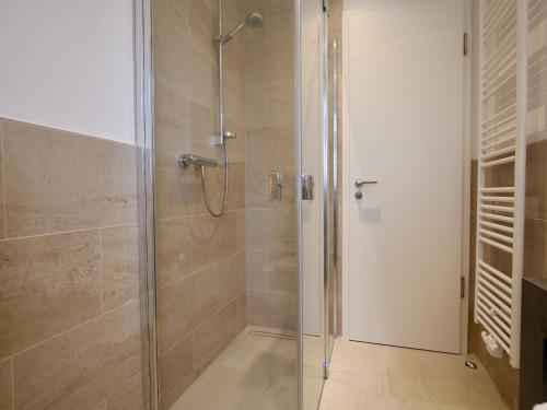 a shower with a glass door in a bathroom at Kleine Charlotte - Traumwohnung mit Terrasse für 4 Personen in Wangerooge