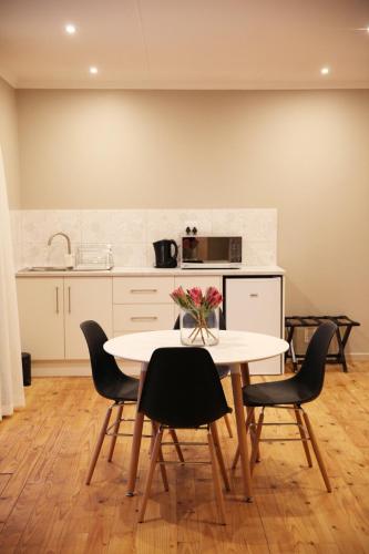 a kitchen with a table with chairs and a counter at Eden Guesthouse B&B in Dana Bay