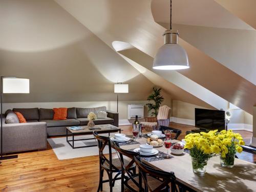 a living room with a table and chairs and a couch at Lisbon Canaan Boutique Apartments Gaivotas by Get Your Stay in Lisbon