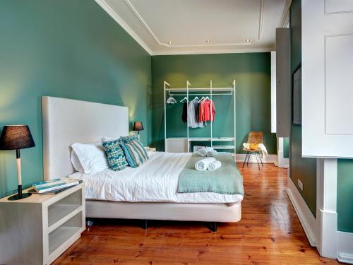 ein Schlafzimmer mit einem Bett und einer grünen Wand in der Unterkunft Lisbon Canaan Boutique Apartments Gaivotas by Get Your Stay in Lissabon