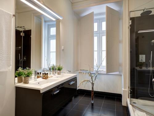 a bathroom with a sink and a large mirror at Lisbon Canaan Boutique Apartments Gaivotas by Get Your Stay in Lisbon