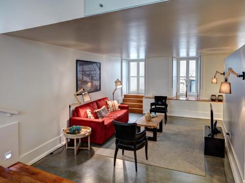 a living room with a red couch and chairs at Lisbon Canaan Boutique Apartments Gaivotas by Get Your Stay in Lisbon