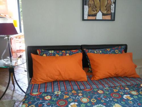 a bed with two orange pillows on top of it at Villa Giannì in Palermo