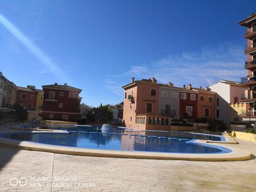 une grande piscine avec des bâtiments en arrière-plan dans l'établissement Apartamento 1 línea playa Porsa playa Alboraya, à Port Saplaya