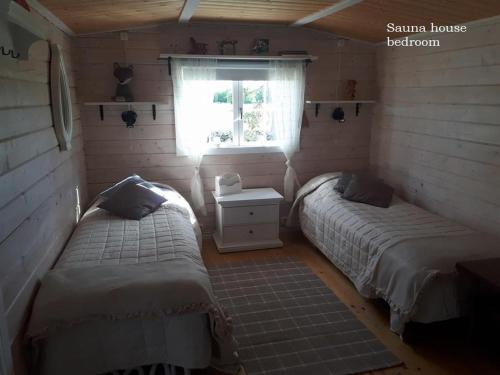 deux lits dans une petite pièce avec une fenêtre dans l'établissement Windmill - Summer house, à Mõega