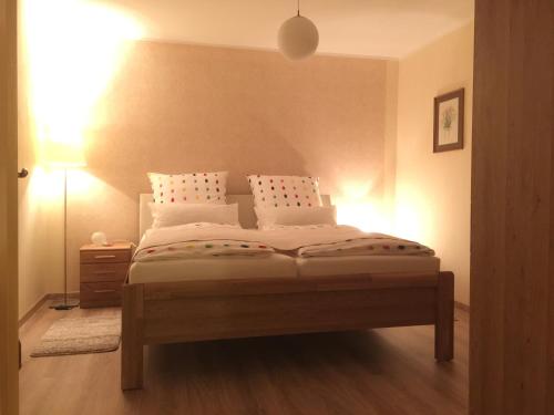 Schlafzimmer mit einem Bett mit weißer Bettwäsche und Kissen in der Unterkunft Ferienwohnung Kalin in Neualbenreuth