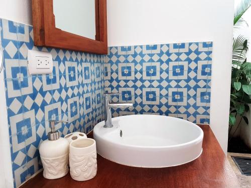 a bathroom with a white sink and blue and white tiles at Lovely new-build colonial house with plunge pool in Granada