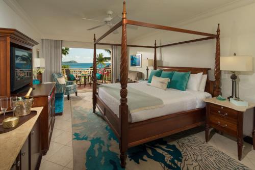 1 dormitorio con cama con dosel y sala de estar. en Sandals Grande St. Lucian Spa and Beach All Inclusive Resort - Couples Only, en Gros Islet