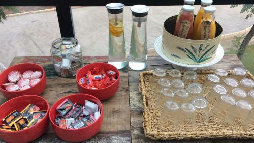 a table with four red containers with bottles and glasses at Balneario Aguas de Villaharta in Villaharta