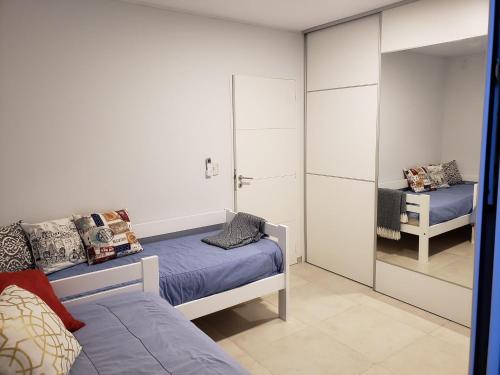 Un dormitorio con dos camas y un espejo. en Torre del Lago I, en Villa Carlos Paz